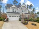 Charming two-story home featuring a gray exterior, attached garage, covered porch, and manicured landscaping at 3548 Willow Green Dr, Apex, NC 27502