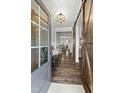 Inviting foyer with hardwood floors, a bench, barn door and an open view into the dining room at 3548 Willow Green Dr, Apex, NC 27502