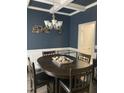 Traditional dining room featuring a dark wood table, wainscoting, and a stylish chandelier at 433 Falling Brook Dr, Kenly, NC 27542