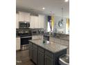 Well-lit kitchen featuring stainless steel appliances, granite countertops, and a center island at 433 Falling Brook Dr, Kenly, NC 27542
