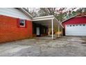 View of the covered parking area and detached garage behind this brick home at 4709 Stafford Dr, Durham, NC 27705