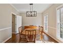 Bright dining room with hardwood floors, wood table with six chairs, and modern lighting at 501 Nantucket Dr, Cary, NC 27513