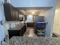 Kitchen with dark cabinets, stainless appliances, and eat-in bar at 5054 Avenida Del Sol Dr, Raleigh, NC 27616