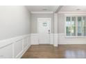 Bright foyer features hardwood floors, decorative wainscoting, and stylish front door with glass accents at 5072 Aspen Meadow St, Raleigh, NC 27616