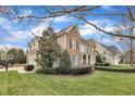 View of the manicured lawn and landscaped home, featuring a basketball hoop at 601 Ballad Creek Ct, Cary, NC 27519