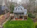 Lake house with a covered porch and open patio, surrounded by a well-maintained lawn at 651 Sagamore Dr, Louisburg, NC 27549