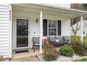 Inviting front porch with seating, decorative plants, and the house number clearly visible at 6923 Fox Haven Pl, Raleigh, NC 27616