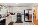 Functional kitchen featuring light-colored cabinets, stainless steel appliances, and wood-look flooring at 6923 Fox Haven Pl, Raleigh, NC 27616