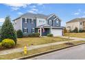 Charming two-story home featuring blue siding, a well-manicured lawn, and a two-car garage at 709 Teal Lake Dr, Holly Springs, NC 27540