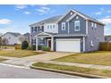 Two-story home featuring blue siding, a well-manicured lawn, and a two-car garage at 709 Teal Lake Dr, Holly Springs, NC 27540
