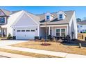 Inviting single-Gathering home featuring a covered porch and an attached two-car garage at 74 Silver Moon Ln, Clayton, NC 27527