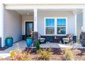Cozy covered front porch with seating area and decorative planters creates a welcoming entrance at 74 Silver Moon Ln, Clayton, NC 27527