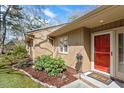 Close up of front entrance. A red door, a potted plant, and a welcome mat at 7914 Yester Ct, Raleigh, NC 27615
