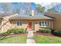 Home's inviting front entrance with a red door, complemented by lovely landscaping at 7914 Yester Ct, Raleigh, NC 27615