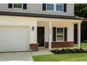 Close up of a two-story home's entrance, including attached garage and brick accents at 804 E D St, Butner, NC 27509