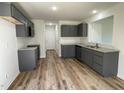 Well-lit kitchen featuring gray cabinets, granite countertops, modern appliances, and wood-look vinyl flooring at 95 Tulipfield Way, Benson, NC 27504