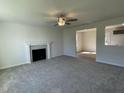 Spacious living room featuring plush carpeting, a ceiling fan, a fireplace, and a seamless open floor plan at 95 Tulipfield Way, Benson, NC 27504