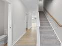 Bright foyer with wood-look flooring, carpeted stairs, and white trim accents at 96 Ripple Way # 316, Clayton, NC 27520