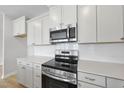 Modern kitchen showcasing stainless steel oven and microwave over quartz countertops and subway tile at 96 Ripple Way # 316, Clayton, NC 27520