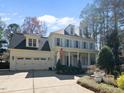 Traditional two-story white home with a two-car garage and beautiful landscaping at 1006 Henny Pl, Raleigh, NC 27614