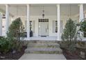 Welcoming front entrance with stone steps and pillars, complemented by elegant landscaping at 1006 Henny Pl, Raleigh, NC 27614