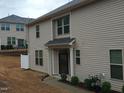 Well-maintained exterior of townhome with covered entryway, private parking, and landscaped front yard at 1022 Azimuth Dr, Durham, NC 27713