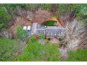 A lush, green canopy surrounds an expansive brick home with a grey rooftop and blue front door at 10726 Trego Trl, Raleigh, NC 27614