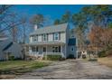 Inviting two-story home with a covered front porch, basketball hoop, and driveway at 1104 Mango Crest Dr, Knightdale, NC 27545