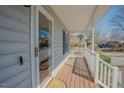 View of the front porch showing a glass storm door and painted gray siding at 1104 Mango Crest Dr, Knightdale, NC 27545