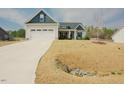 Beautiful home featuring a two-car garage, blue accents, and a well-maintained lawn at 129 Edgefield Dr, Sanford, NC 27332