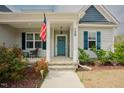 Inviting front porch with an American flag and pleasant landscaping at 129 Edgefield Dr, Sanford, NC 27332