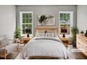 Staged main bedroom with soft decor, featuring two windows and cozy lighting at 13 Herndon Ct, Clayton, NC 27520