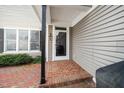 Inviting front porch with brick flooring and a storm door with black accents at 1331 Langdon Pl, Pittsboro, NC 27312