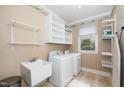 Functional laundry room with shelving, utility sink, and front-load washer and dryer at 1331 Langdon Pl, Pittsboro, NC 27312