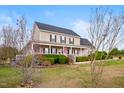Attractive home with a large front porch, complemented by blooming trees and manicured shrubbery at 170 Blande Dr, Kenly, NC 27542