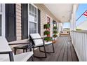 Inviting front porch with comfortable seating, potted plants, and a clear view of the home's entrance at 170 Blande Dr, Kenly, NC 27542