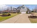 Two-story home featuring an attached garage, covered porch and manicured landscaping at 1726 River Club Way, Franklinton, NC 27525