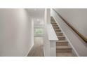 Bright hallway leading to carpeted stairs and an open room with ample natural light and new wood floors at 180 Starlight St, Sanford, NC 27330