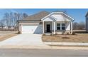 Inviting home featuring a brick and siding exterior, attached garage, and a freshly poured concrete driveway at 185 White Birch Ln, Angier, NC 27501