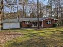 Charming brick home with a front porch swing, well-maintained lawn, and surrounding trees at 209 High House Rd, Cary, NC 27513