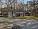 Charming brick home with a front porch swing, well-maintained lawn, and surrounding trees at 209 High House Rd, Cary, NC 27513