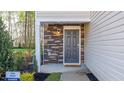 Home's inviting entryway features a stone surround and stylish front door at 2148 Monk Dr, Haw River, NC 27258