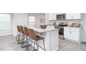 Modern kitchen island with stainless steel appliances, white cabinets, granite countertops, and bar stool seating at 2160 Monk Dr, Haw River, NC 27258