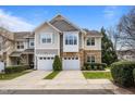 Beautiful townhome features a two-car garage, manicured landscaping, and a mix of stone and siding exterior at 2302 Wispy Green Ln, Raleigh, NC 27614