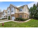 Attractive townhome showcasing a two-car garage, stone accents, and lush green lawn at 2302 Wispy Green Ln, Raleigh, NC 27614