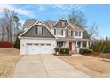 Charming two-story home with a manicured lawn and a convenient two-car garage at 244 Winding Oak Way, Clayton, NC 27520