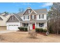 Inviting two-story home with a charming front porch, a red door and manicured landscaping at 244 Winding Oak Way, Clayton, NC 27520