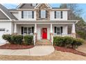 Close-up view of a charming front porch with a vibrant red door and classic white columns at 244 Winding Oak Way, Clayton, NC 27520
