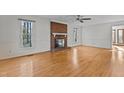 Spacious living room with hardwood floors, a brick fireplace, and bright, natural lighting at 2501 Huntsman Trl, Zebulon, NC 27597