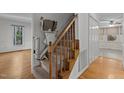 Carpeted staircase with a wooden banister featuring a lift for increased accessibility at 2501 Huntsman Trl, Zebulon, NC 27597